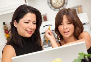 Attractive Hispanic Mother and Daughter on the Laptop photo