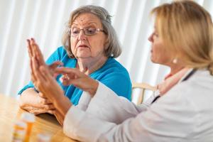 Female Doctor Talking with Senior Adult Woman About Hand Therapy photo