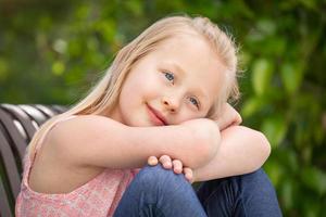 Pretty Young Caucasian Girl Portrait Sitting On The Bench At The Park photo