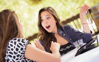 Expressive Young Adult Girlfriends Using Their Computer Electronics Outdoors photo