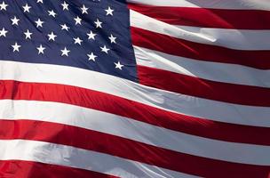 American Flag Waving In Wind Against a Deep Blue Sky photo