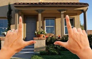 manos femeninas enmarcando una hermosa casa foto