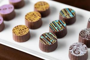 Dulces de chocolate fino artesanal en un plato para servir foto