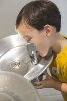 Mixed Race Boy Drinking From the Water Fountain photo