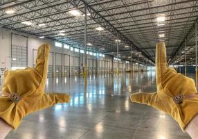 Framing Hands Wearing Leather Construction Gloves in Empty Industrial Warehouse. photo