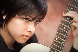 Attractive Ethnic Girl Plays Guitar photo