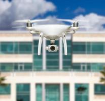 sistema de aviones no tripulados quadcopter drone en el aire cerca de la ciudad y el edificio corporativo foto