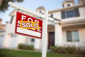 casa en venta signo de bienes raíces frente a casa nueva foto