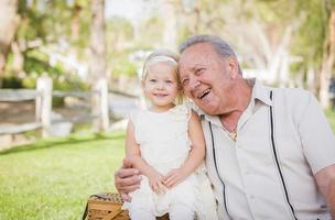 abuelo y nieta abrazándose afuera en el parque foto