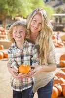 atractivo retrato de madre e hijo en el huerto de calabazas foto