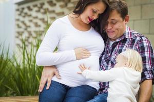 Adorable Baby Girl with Young Pregnant Parents photo