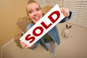 Woman and Doggy with Sold Sign Near Moving Boxes photo