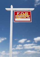 frente a la derecha vendido en venta signo de bienes raíces en un cielo azul con nubes. foto