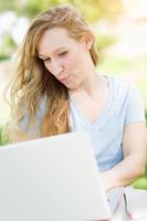 Young Adult Woman Live Video Chatting Outdoors Using Her Laptop. photo