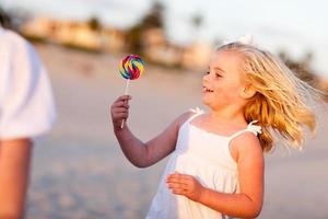 Adorable Little Girl Enjoying Her Lollipop Outside photo