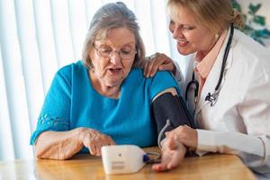 Senior Adult Woman Learning From Female Doctor to Use Blood Pressure Machine photo