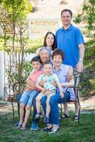 familia china y caucásica sentada en un banco foto