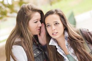 Mixed Race Woman Whispering Secrets Outside photo