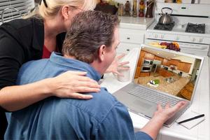 Couple In Kitchen Using Laptop - Home Improvement photo