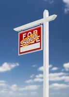 Left Facing Sold For Sale Real Estate Sign on a Blue Sky with Clouds. photo