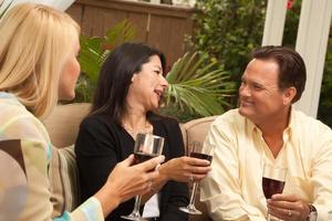 Three Friends Enjoying Wine on the Patio photo