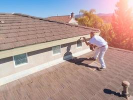 Professional Painter Using A Brush to Paint House Fascia photo