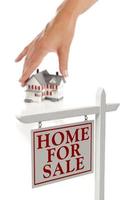 Womans Hand Choosing Home with Real Estate Sign in Front photo