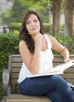 Young Adult Female Student on Bench Outdoors photo