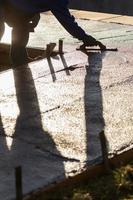 Construction Worker Smoothing Wet Cement With Trowel Tools photo