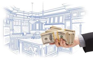 Hand Holding Cash Over Custom Kitchen Design Drawing photo