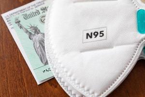 N95 Medical Face Mask Resting On IRS Covid-19 Economic Relief Check photo