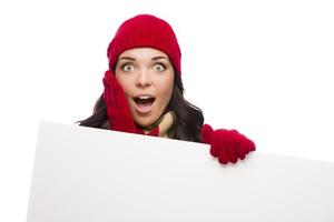 chica sorprendida con sombrero de invierno y guantes tiene un cartel en blanco foto