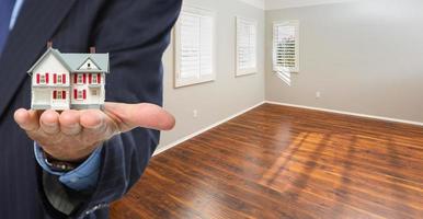 Real Estate Agent Holding Model Home Iside Empty Room of New House photo