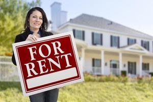 Hispanic Female Holding For Rent Sign In Front of House photo