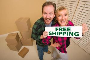 Goofy Couple Holding Free Shipping Sign Surrounded by Boxes photo