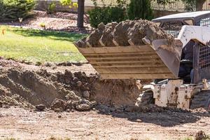 excavadora pequeña excavando en el patio para la instalación de piscinas foto