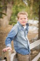 Handsome Young Boy Against Fence in Park photo