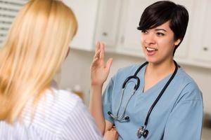 Attractive Mixed Race Young Female Doctor Talking with Patient photo