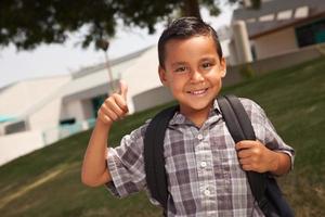 feliz joven colegial hispano con los pulgares hacia arriba foto