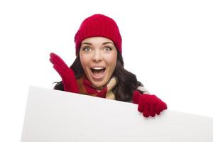 chica sorprendida con sombrero de invierno y guantes tiene un cartel en blanco foto