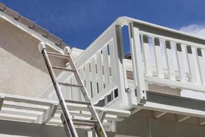 escalera de construcción apoyada en la cubierta de la casa blanca foto