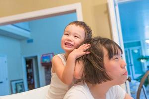 Happy Mixed Race Chinese and Caucasian Boy Having Fun with Chinese Mother Inside House photo