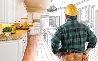 Male Contractor with Hard Hat and Tool Belt Looking At Custom Kitchen Drawing Photo Combination On White.