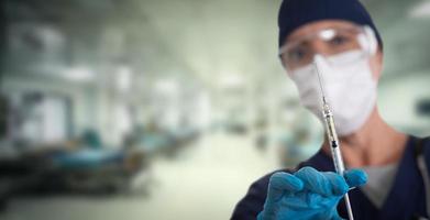 médico o enfermera sosteniendo jeringa médica con aguja dentro del hospital. foto