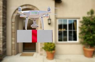 Unmanned Aircraft System UAV Quadcopter Drone Delivering Box With Red Ribbon To Home photo