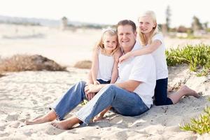 papá guapo y sus lindas hijas en la playa foto