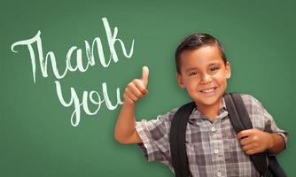 Hispanic Boy with Thumbs Up in Front of Chalk Board with Thank You Written On It photo