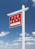 Left Facing For Rent Real Estate Sign on a Blue Sky with Clouds. photo