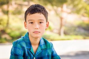 Outdoor portrait of a biracial Chinese and Caucasian boy. photo