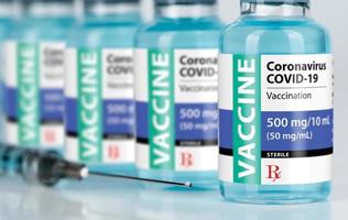 Coronavirus COVID-19 Vaccine Vials and Syringe On Reflective Surface photo